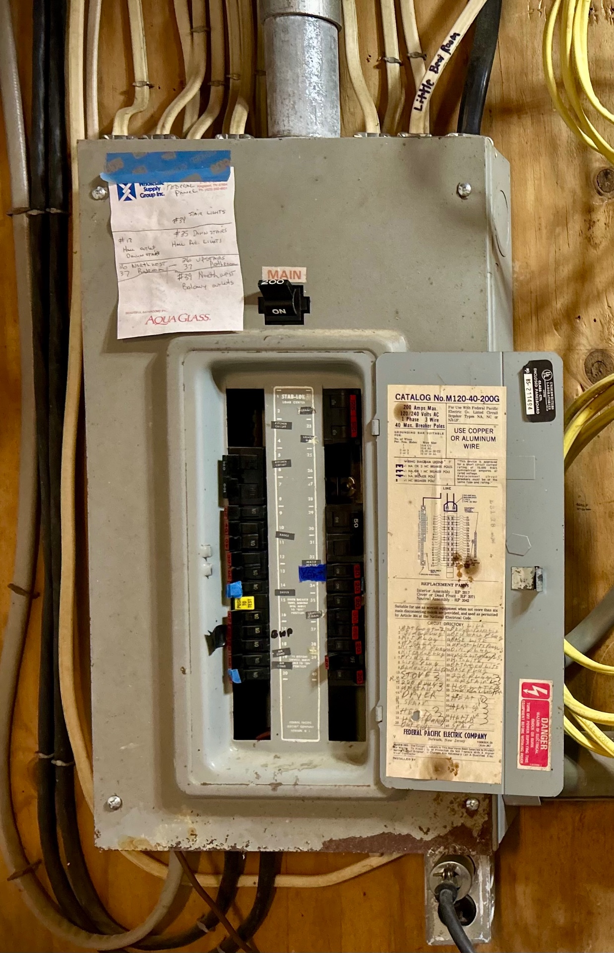 A Federal Pacific Stab-Lok 200 amp panel with the dead front open, showing the original handwritten circuit directory.